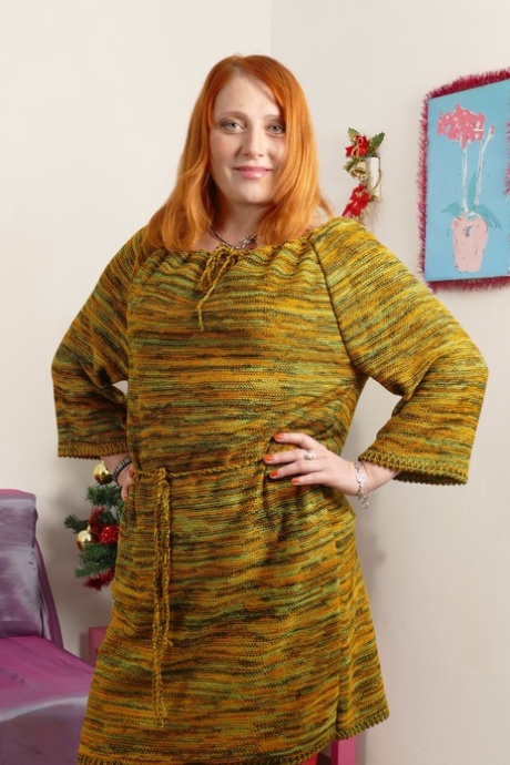 Thick redheaded housewife satisfies her ginger pussy with a sex toy on a sofa