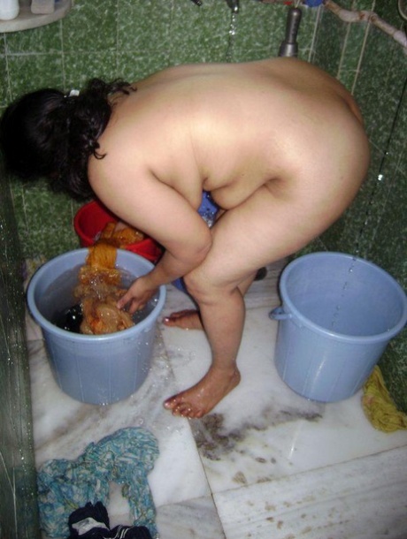 Indian fatty washes her clothes while taking a shower at the same time