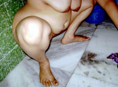 Indian fatty washes her clothes while taking a shower at the same time