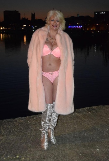 Mature blonde Dimonty gets naked on a city street in silver boots