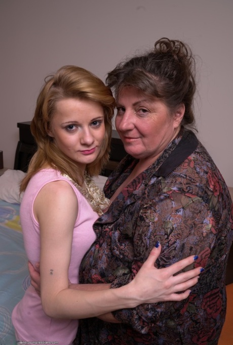 Fat mature woman and tiny teen girl engage in lesbian sex acts upon a bed