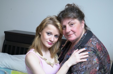 Fat mature woman and tiny teen girl engage in lesbian sex acts upon a bed
